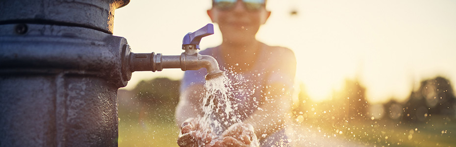 boy with hands under water faucet